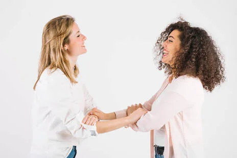 Two women holding hands and smiling