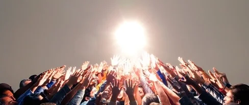 Hands raised towards sunlight