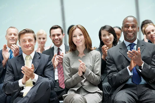 A seated business audience applauding